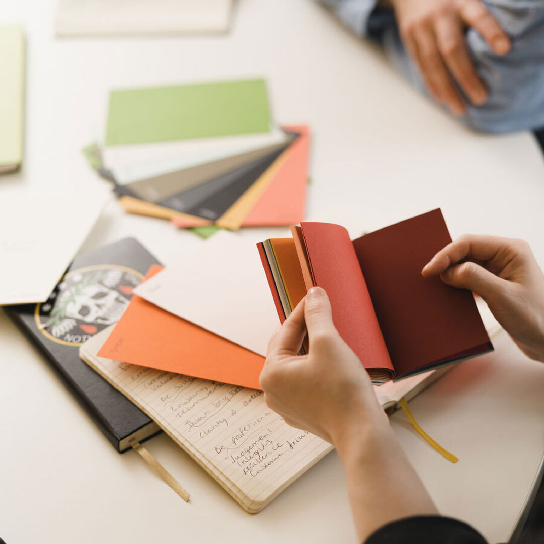 Design materials showing a refined colour palette and paper stock samples.